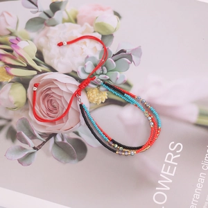 Bohemian multilayer beaded bracelet with colorful charms on a floral backdrop