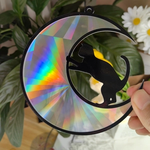 Detail of holographic suncatcher featuring a black cat silhouette on a crescent moon