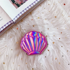 Macro detail of a shell-shaped holographic pink vanity mirror on starry white mesh fabric