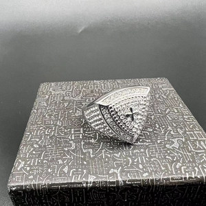 Macro view of silver stainless steel ring with rhinestones and black cross detail