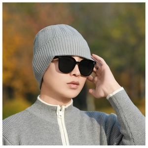 Detailed texture of light grey knitted beanie with vertical striped pattern for winter