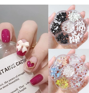 Close-up of 3D nail art charms with bows and pearls in a flower-shaped storage case