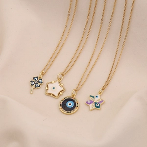 Golden Evil Eye necklaces featuring clover and star designs on beige fabric background