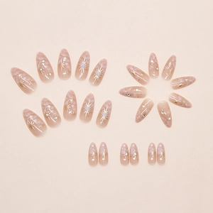 Detail of almond-shaped marble press-on nails with gold stars and crystal rhinestones