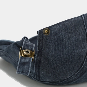 Dettaglio macro del tessuto denim blu lavato con fibbia in ottone vintage regolabile