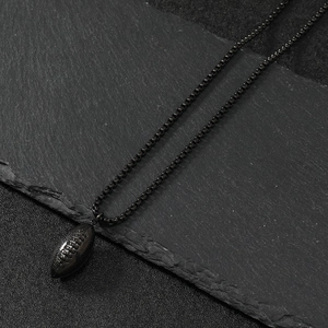 Retro black American football pendant with box chain on dark slate background