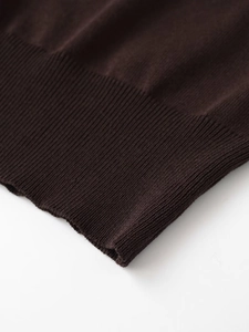 Macro view of dark coffee knitted fabric showing premium ribbed hem detail and texture