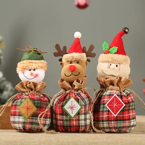 Three Christmas burlap drawstring gift bags featuring snowman, elk, and Santa Claus patterns