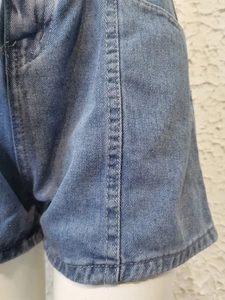 Primo piano del tessuto denim blu con cuciture dettagliate e trama intrecciata di qualità