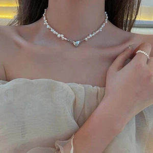 Barockperlenkette mit silbernem Herzanhänger am Hals des Models für elegante Damen