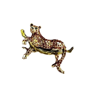 Elegant gold leopard brooch with brown enamel spots crawling on a tree branch