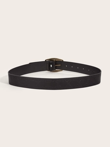Detail of vintage black leather belt with embossed texture and bronze metal buckle