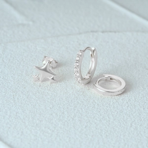 Detailed close-up of 925 sterling silver star studs and hoop earrings set with zircons