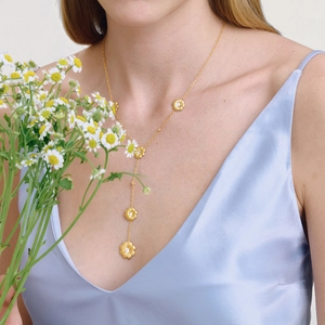 Détail du collier en Y marguerite en or 18K avec zircon sur un mannequin en soie