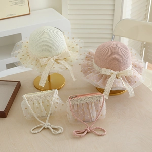 Detail of girl's straw sun hat and matching bag set with lace ribbons and polka dot mesh