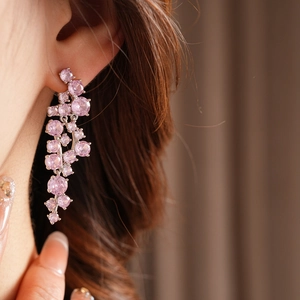 Elegant silver tassel earrings with pink zircons worn by a model for a formal look