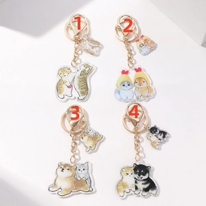 Close-up of four acrylic cat and dog keychains with gold metal clips on white background