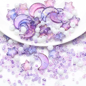 Detailed macro view of purple gold-foil moon and star acrylic beads with white seed beads