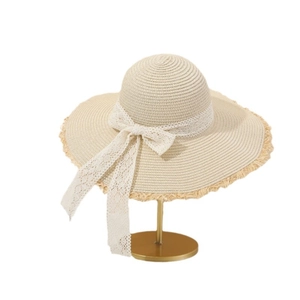 Women's summer straw hat with wide brim, white floral lace bow, and frayed edge detail