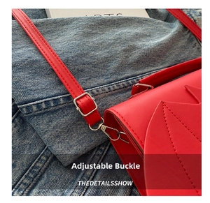 Detail of red leather strap with adjustable silver metal buckle and geometric stitching