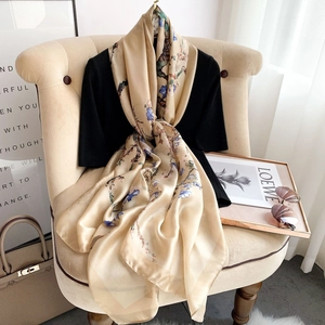 Elegant champagne gold silk scarf with blue floral print and premium satin finish texture