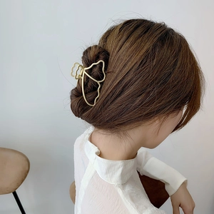 Elegant gold butterfly metal hair claw clip for women shown on model for half-up hair styles