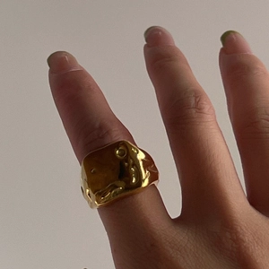 Irregular liquid lava texture wide band ring with 18k gold plating shown on hand