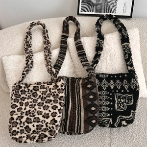 Three plush leopard and geometric pattern tote bags displayed on a cozy soft sofa