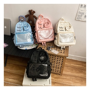 Detail of multi-color nylon school backpacks with transparent heart windows and card slots
