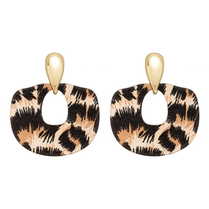 Boucles d'oreilles en résine léopard et clous goutte d'or sur fond blanc pur