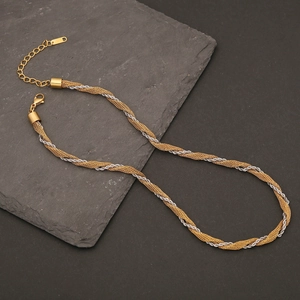Detail of two-tone gold and silver Cuban chain link necklace on dark slate stone