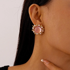 Macro detail of vintage floral earring with pink resin stone and imitation pearls