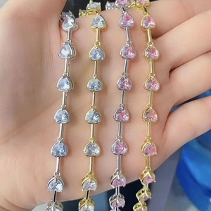 Detailed view of four heart bracelets in gold and silver with pink crystals