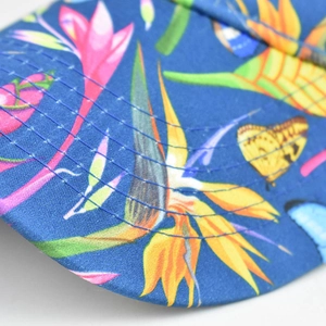 Detail of blue sun visor hat featuring tropical bird of paradise floral print and stitching