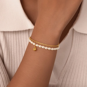 Double-layer gold stainless steel chain bracelet with white pearls and small pendant on wrist