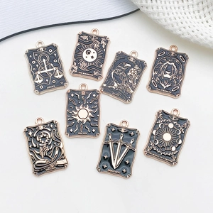 Flat lay of vintage black and rose gold enamel tarot card charms for DIY jewelry making