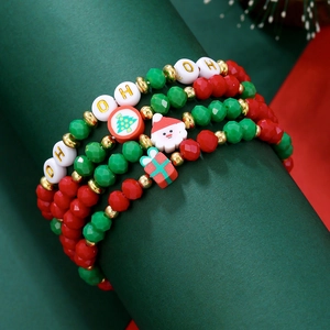 Gros plan de bracelets de Noël empilés avec des charms festifs sur présentoir