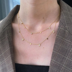 Close-up of gold double-layer necklace with geometric zircon pendants on model