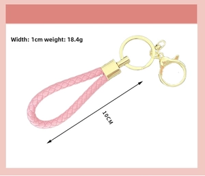 Detailed view of pink woven leather keychain showing 10cm length and 1cm width dimensions