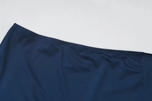 Détails macro du tissu bleu foncé et coutures précises sur l'ourlet de la taille du vêtement