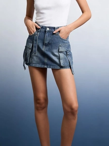 Detail of high-waist denim cargo mini skirt with flap pockets and D-ring belt