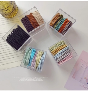 Top view of striped elastic hair ties in acrylic storage jars with aesthetic decor