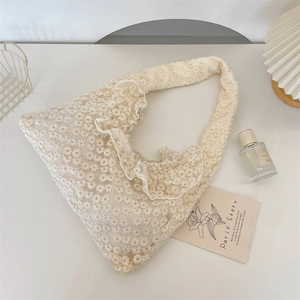 Detail of cream daisy embroidery lace and ruffled edges on this chic summer tote bag