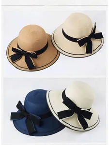 Detailed close-up of wide brim straw sun hats featuring elegant black ribbon bow accents