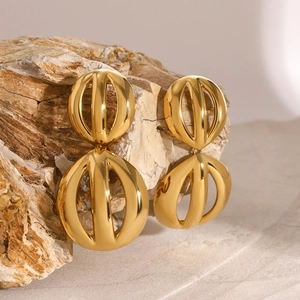 Détail macro de boucles d'oreilles doubles sphères creuses dorées à l'or 18 carats