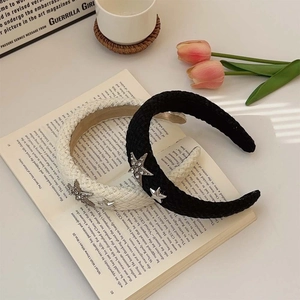 French vintage black pleated headband with silver star pendants on magazine background