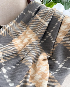 Nahaufnahme des weichen dicken Schals mit Hahnentrittmuster in Grau und Beige