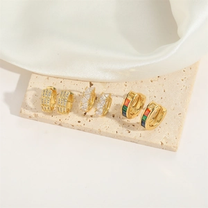 Vintage French style gold huggie earrings set with colorful gemstones on stone