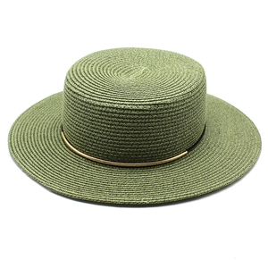 Dettaglio del cappello di paglia verde oliva con decorazione metallica dorata elegante