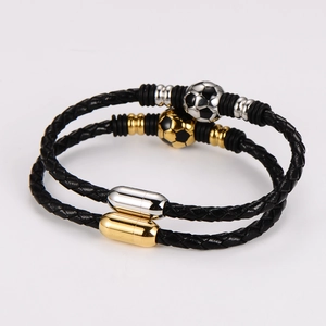 Detail eines geflochtenen Lederarmbands mit Fußball-Magnetverschluss in Schwarz und Gold-Optik